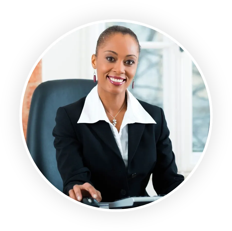 A woman in business attire sitting at her desk.